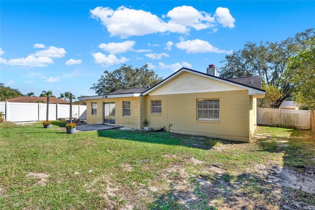 back of house featuring a patio area and a lawn