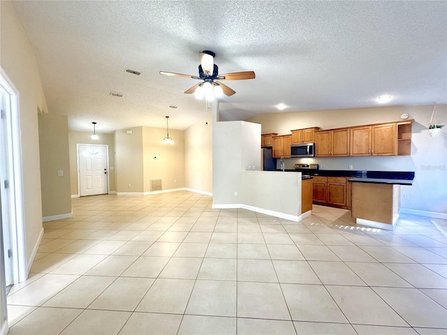 kitchen with kitchen peninsula, appliances with stainless steel finishes, light tile patterned floors, hanging light fixtures, and lofted ceiling