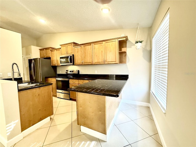 kitchen featuring appliances with stainless steel finishes, a textured ceiling, vaulted ceiling, sink, and light tile patterned flooring