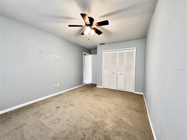 unfurnished bedroom featuring carpet flooring, ceiling fan, a textured ceiling, and a closet