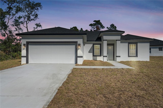 prairie-style house with a yard and a garage