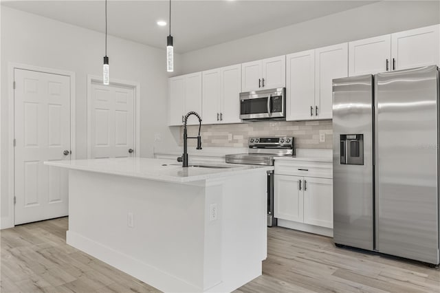 kitchen featuring white cabinetry, stainless steel appliances, and a kitchen island with sink