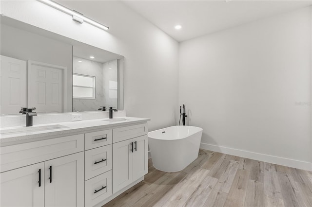 bathroom featuring hardwood / wood-style floors, vanity, and separate shower and tub