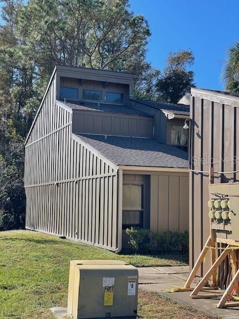 5466 Pine Creek Dr Unit 2002, Orlando, FL 32811 - view of home's exterior featuring a shingled roof and a yard