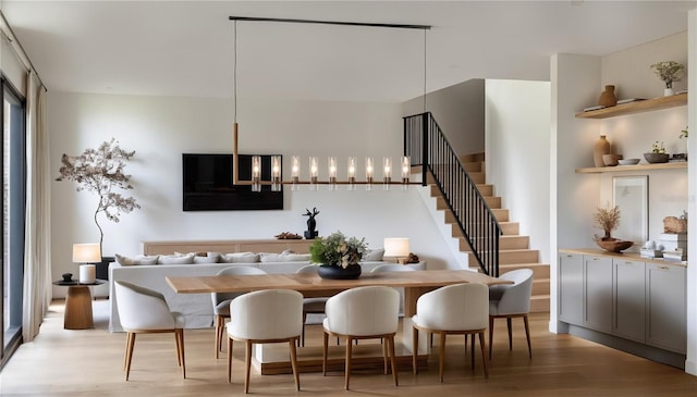 dining area with a notable chandelier and light hardwood / wood-style flooring