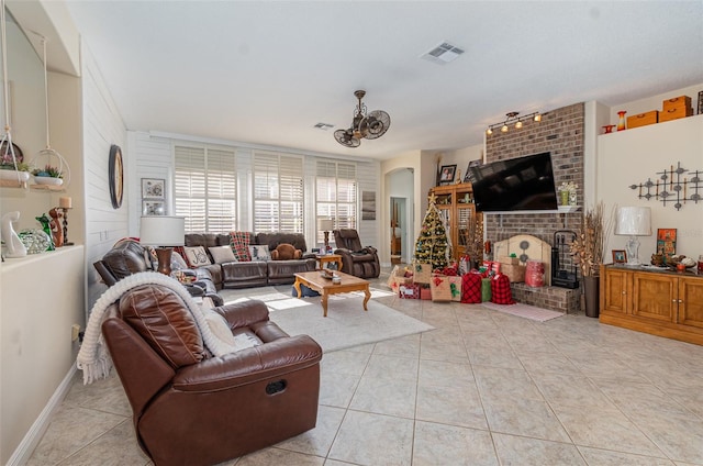 tiled living room featuring a brick fireplace