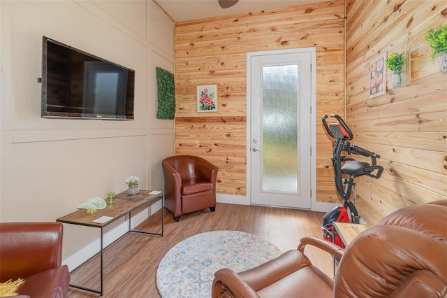 living area with wood walls and light hardwood / wood-style flooring