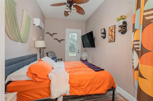 bedroom with a wall unit AC and ceiling fan