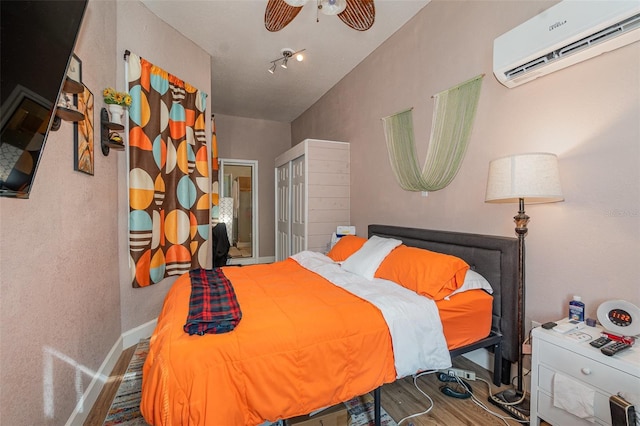 bedroom with a closet, wood-type flooring, an AC wall unit, ceiling fan, and lofted ceiling