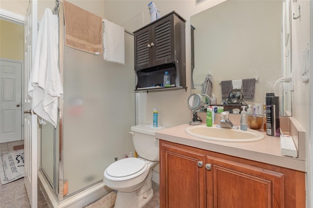 bathroom featuring toilet, vanity, tile patterned flooring, and walk in shower