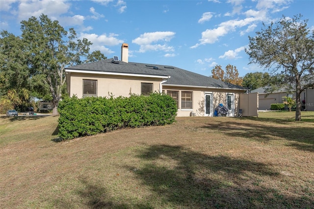 rear view of house featuring a lawn