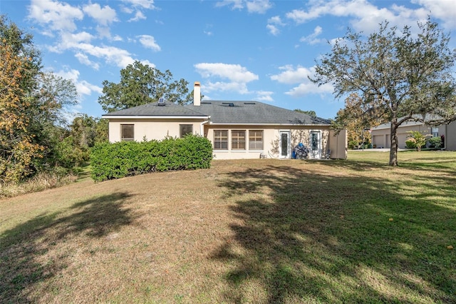 rear view of property with a yard