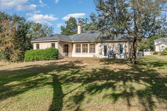 back of house with a lawn