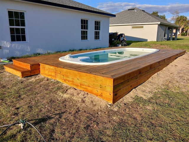 view of swimming pool with a wooden deck and a hot tub