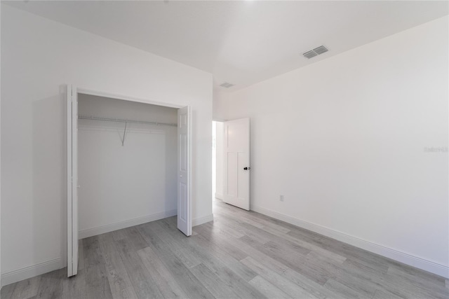 unfurnished bedroom with light hardwood / wood-style flooring and a closet