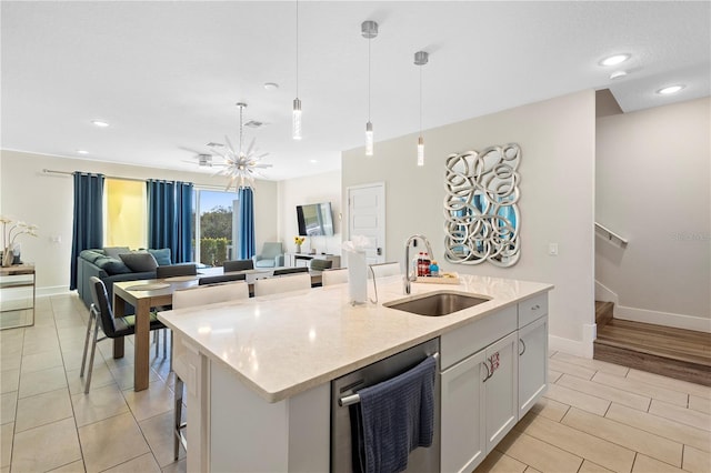 kitchen with a kitchen island with sink, sink, pendant lighting, dishwasher, and white cabinets