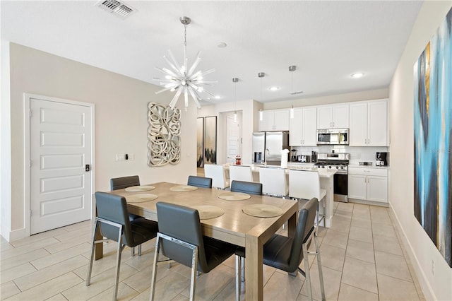 dining room with light tile patterned flooring and a chandelier