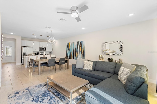 living room with ceiling fan with notable chandelier and light tile patterned flooring