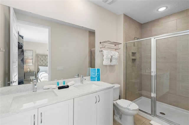 bathroom featuring tile patterned flooring, vanity, toilet, and walk in shower