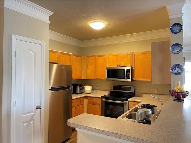 kitchen featuring kitchen peninsula, appliances with stainless steel finishes, ornamental molding, a textured ceiling, and hardwood / wood-style flooring