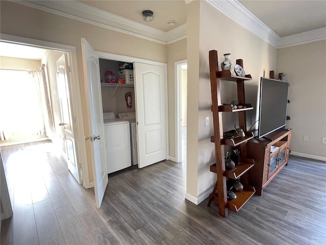 hall featuring dark hardwood / wood-style flooring, ornamental molding, and washing machine and clothes dryer