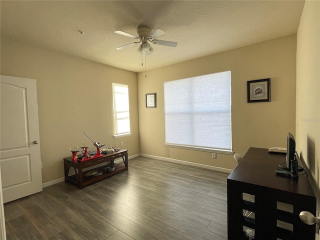 home office with hardwood / wood-style floors, ceiling fan, and a textured ceiling