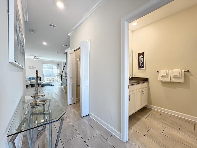 hall featuring sink and ornamental molding