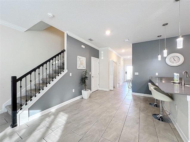 kitchen with a kitchen breakfast bar, hanging light fixtures, and ornamental molding