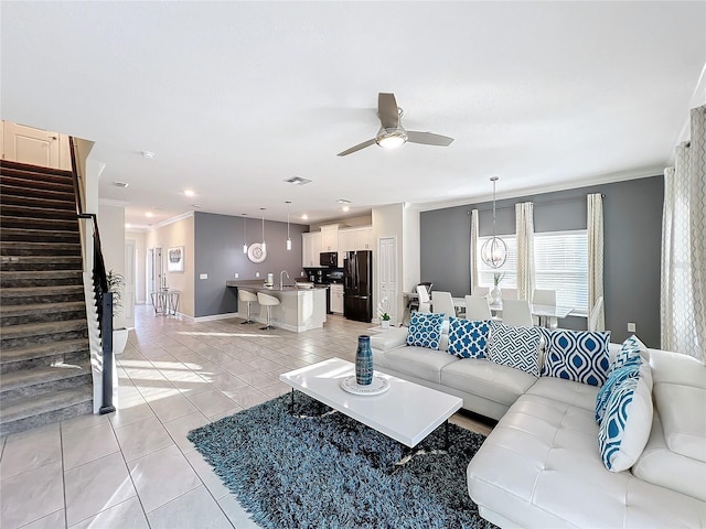 tiled living room featuring ceiling fan, ornamental molding, and sink