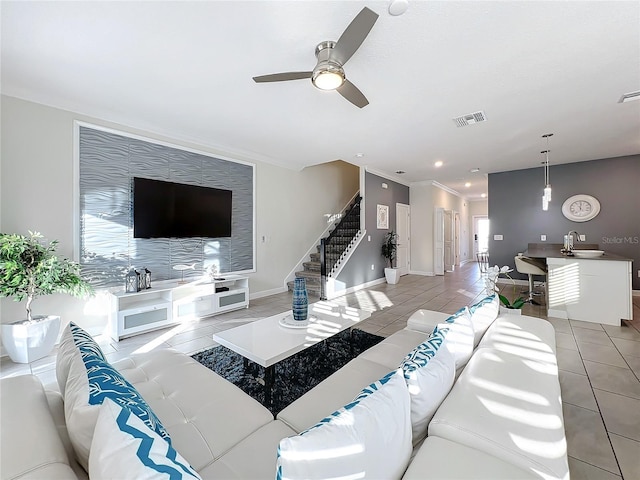 living room with crown molding, sink, ceiling fan, light tile patterned floors, and a healthy amount of sunlight