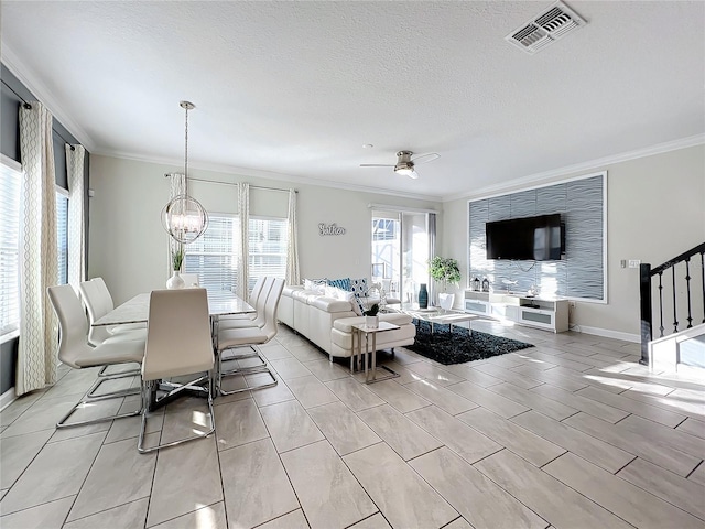 living room with a textured ceiling, crown molding, and ceiling fan with notable chandelier