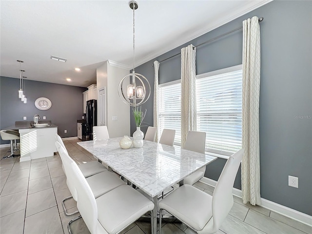 tiled dining area featuring crown molding, a notable chandelier, and sink