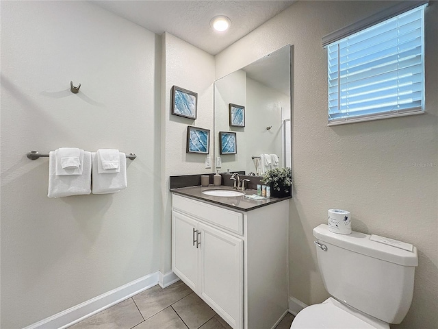 bathroom featuring tile patterned floors, vanity, and toilet