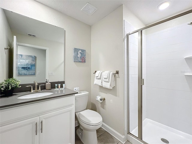 bathroom with tile patterned floors, vanity, toilet, and a shower with shower door