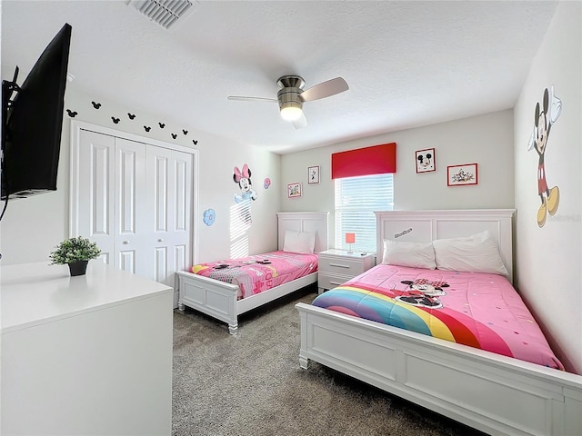 bedroom with ceiling fan, carpet floors, a textured ceiling, and a closet