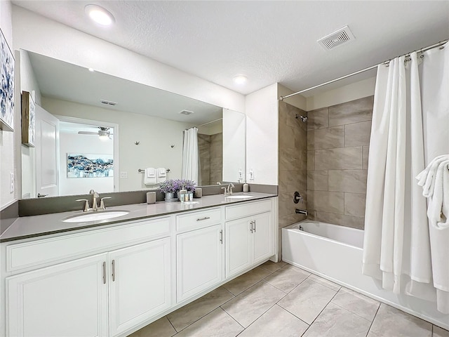 bathroom with tile patterned flooring, vanity, a textured ceiling, and shower / tub combo