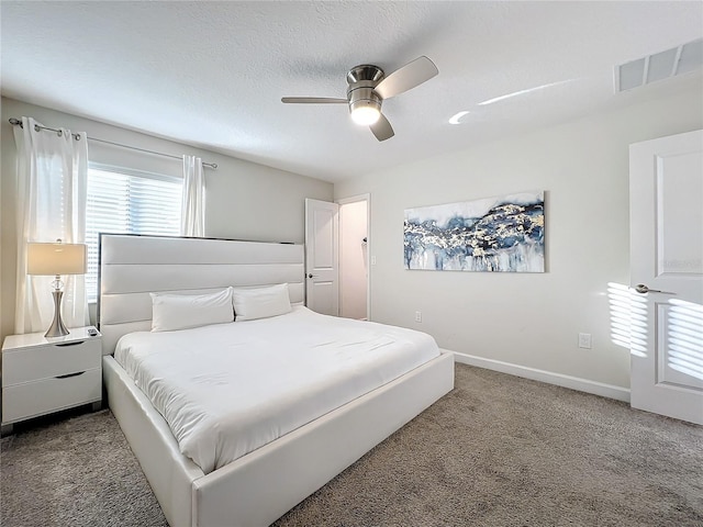 carpeted bedroom featuring ceiling fan and a textured ceiling