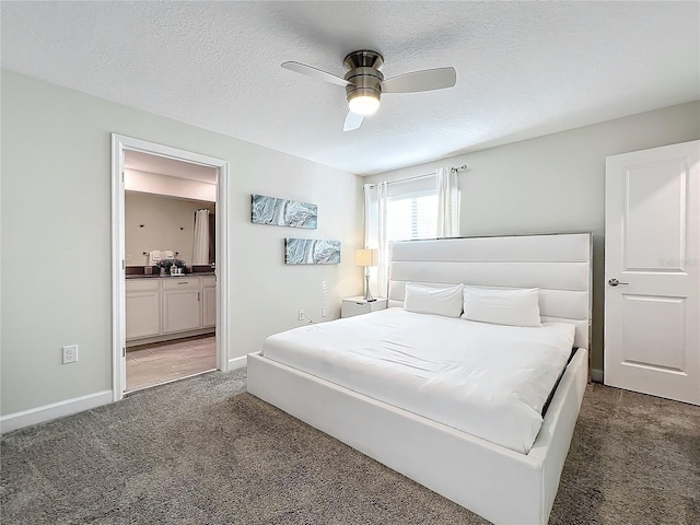 bedroom with dark colored carpet, a textured ceiling, ensuite bath, and ceiling fan