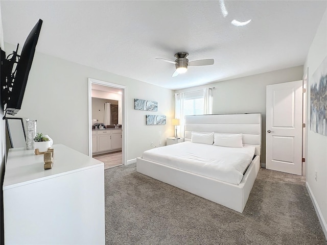 carpeted bedroom featuring a textured ceiling, ensuite bath, and ceiling fan