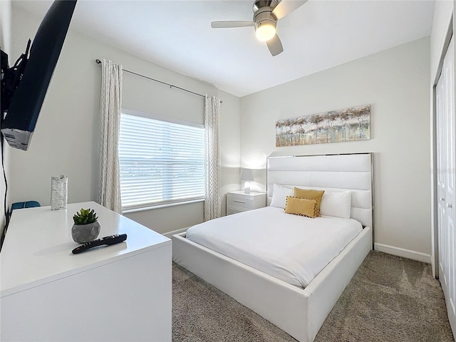 bedroom with dark colored carpet, a closet, and ceiling fan