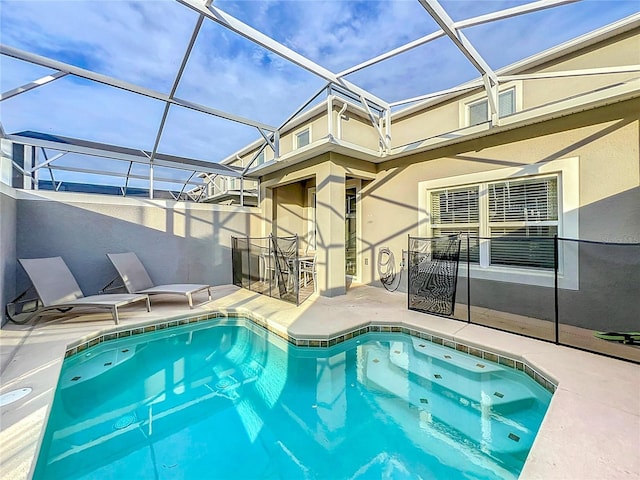 view of pool with glass enclosure and a patio