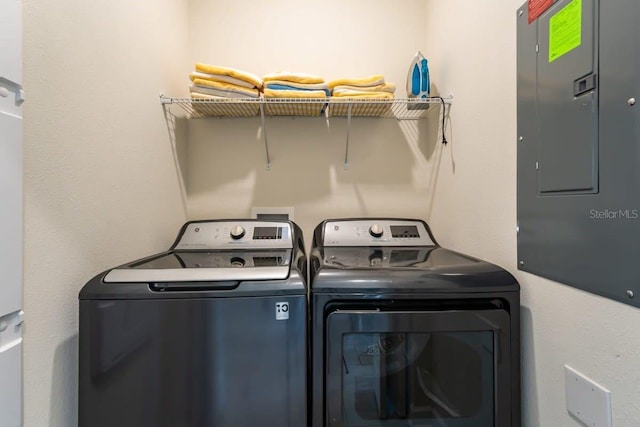 laundry area with washing machine and dryer and electric panel