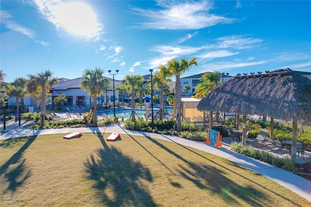 view of property's community with a lawn and a pool