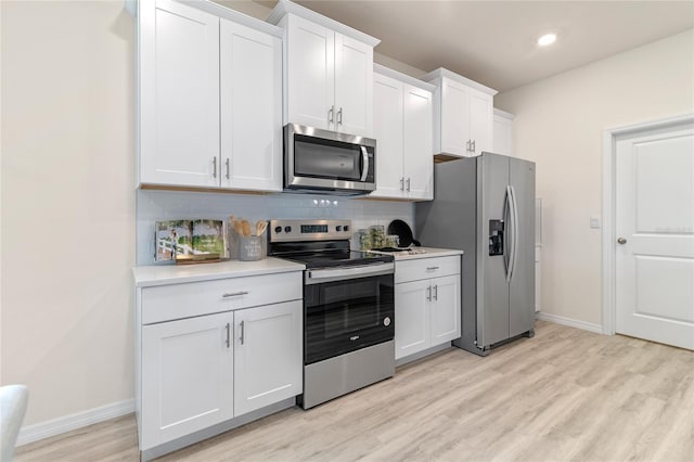 kitchen with decorative backsplash, stainless steel appliances, light hardwood / wood-style floors, and white cabinets