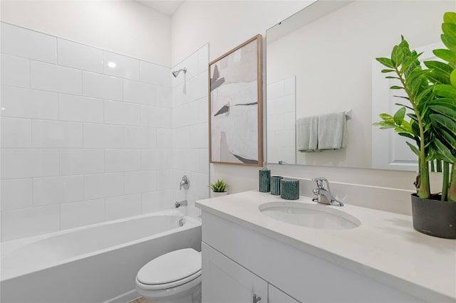 full bathroom featuring tiled shower / bath combo, vanity, and toilet