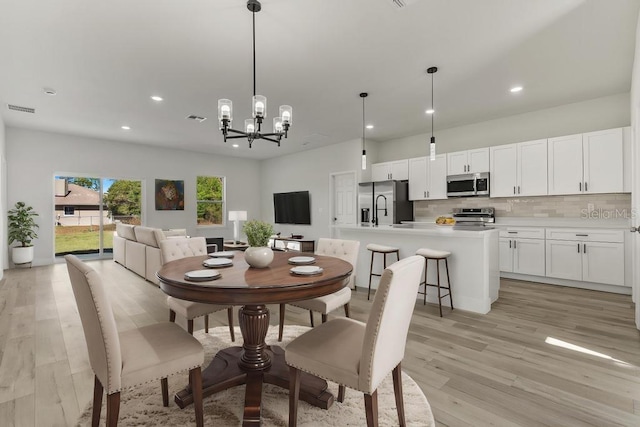 4479 SW 170th Rd, Ocala, FL 34473 - dining space with light wood-type flooring, an inviting chandelier, visible vents, and recessed lighting