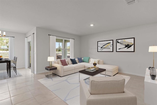 living room with plenty of natural light, light tile patterned floors, and an inviting chandelier