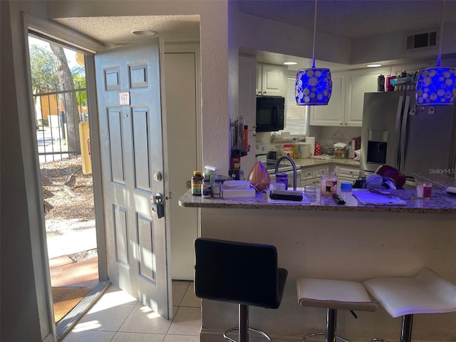 kitchen with kitchen peninsula, a breakfast bar, stainless steel appliances, pendant lighting, and white cabinets