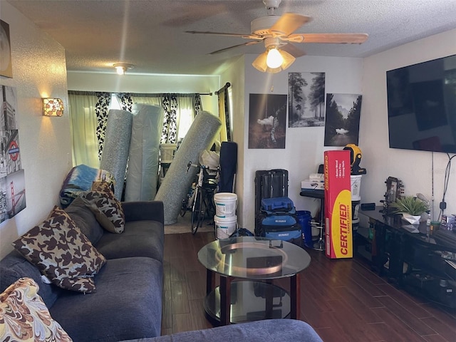 living room featuring a textured ceiling, ceiling fan, and dark wood-type flooring