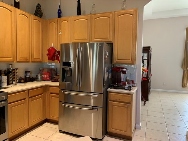 kitchen featuring tasteful backsplash, stainless steel refrigerator with ice dispenser, and light tile patterned floors